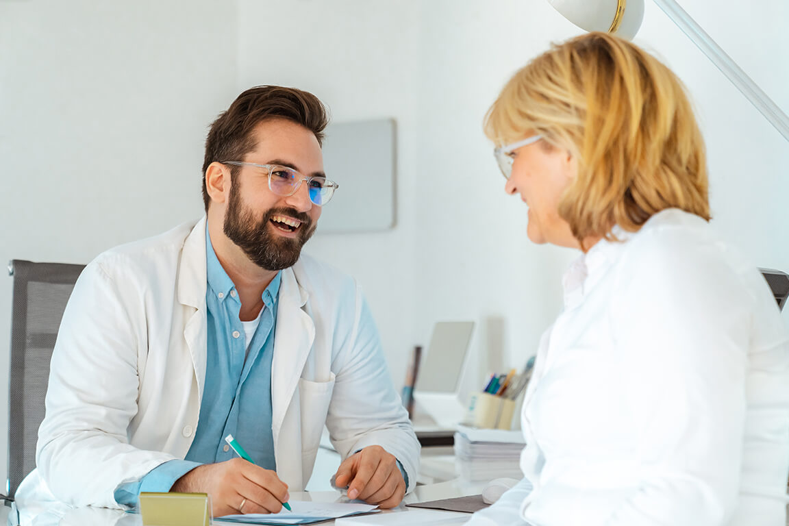 An optometrist enthusiastically discussing his diagnosis to his happy patient